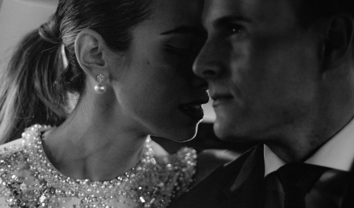 Close up black and white image of bride & groom sitting in the back of a car