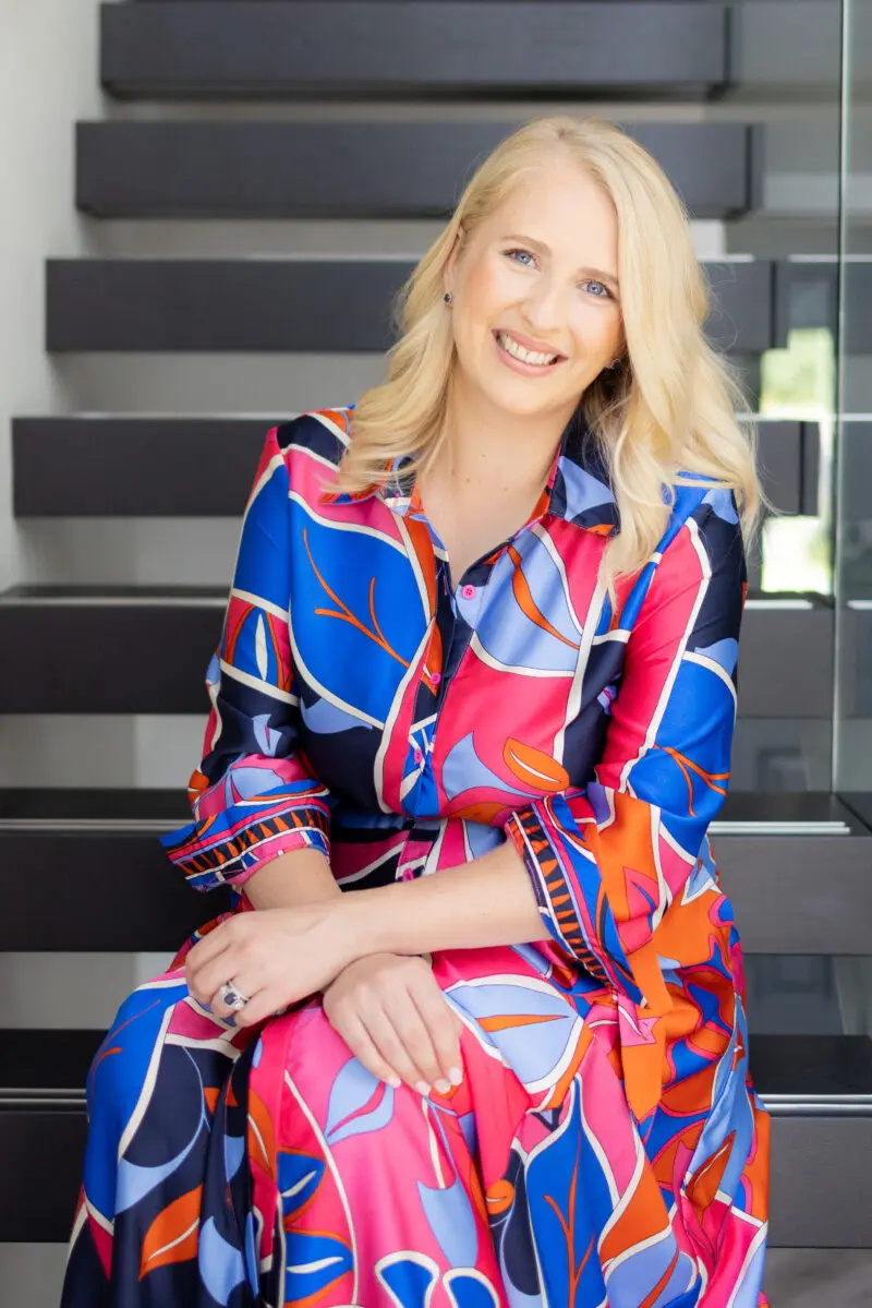 Luxury wedding & events planner Hannah Hope sitting on stairs in brightly coloured dress