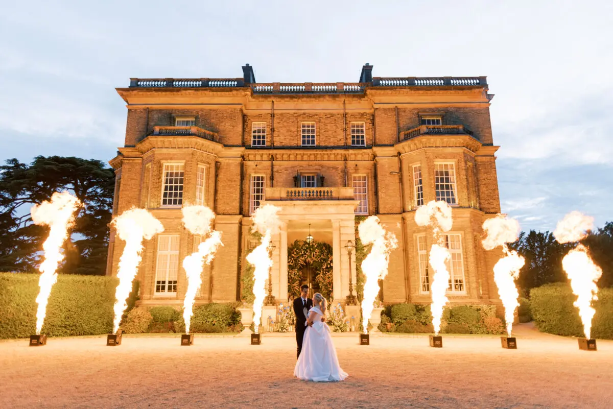 Bride and groom infront of Hedsor House with flames