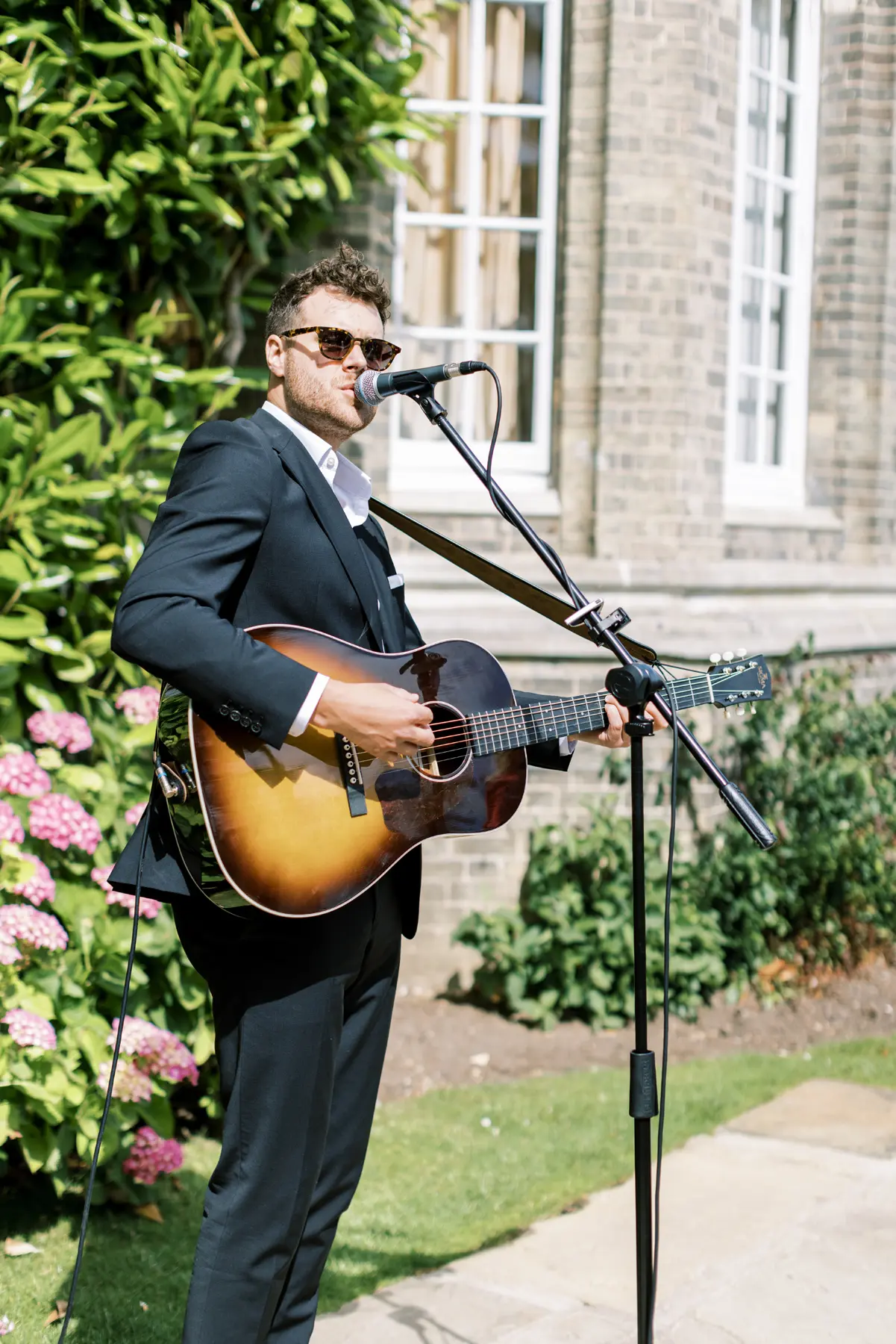 Hedsor House wedding Planner - male wedding singer playing guitar in garden
