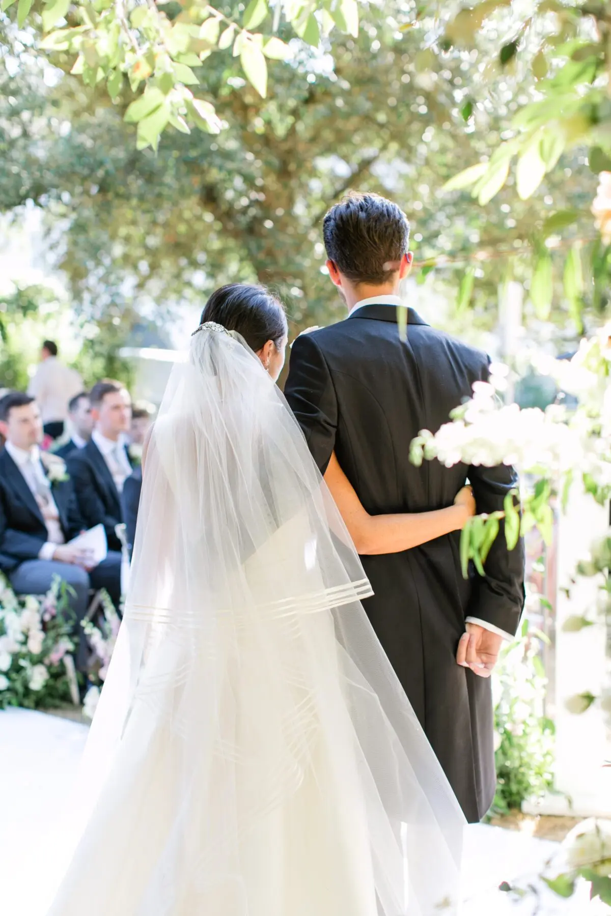 bride and groom hugging during ceremony bride and groom posing on steps outside conservatory classic wedding dinner design in conservatory - Syon Park Wedding
