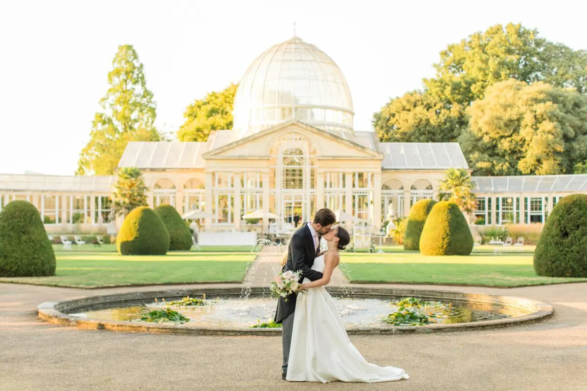 bride and groom kissing outside conservatory - Syon Park Wedding