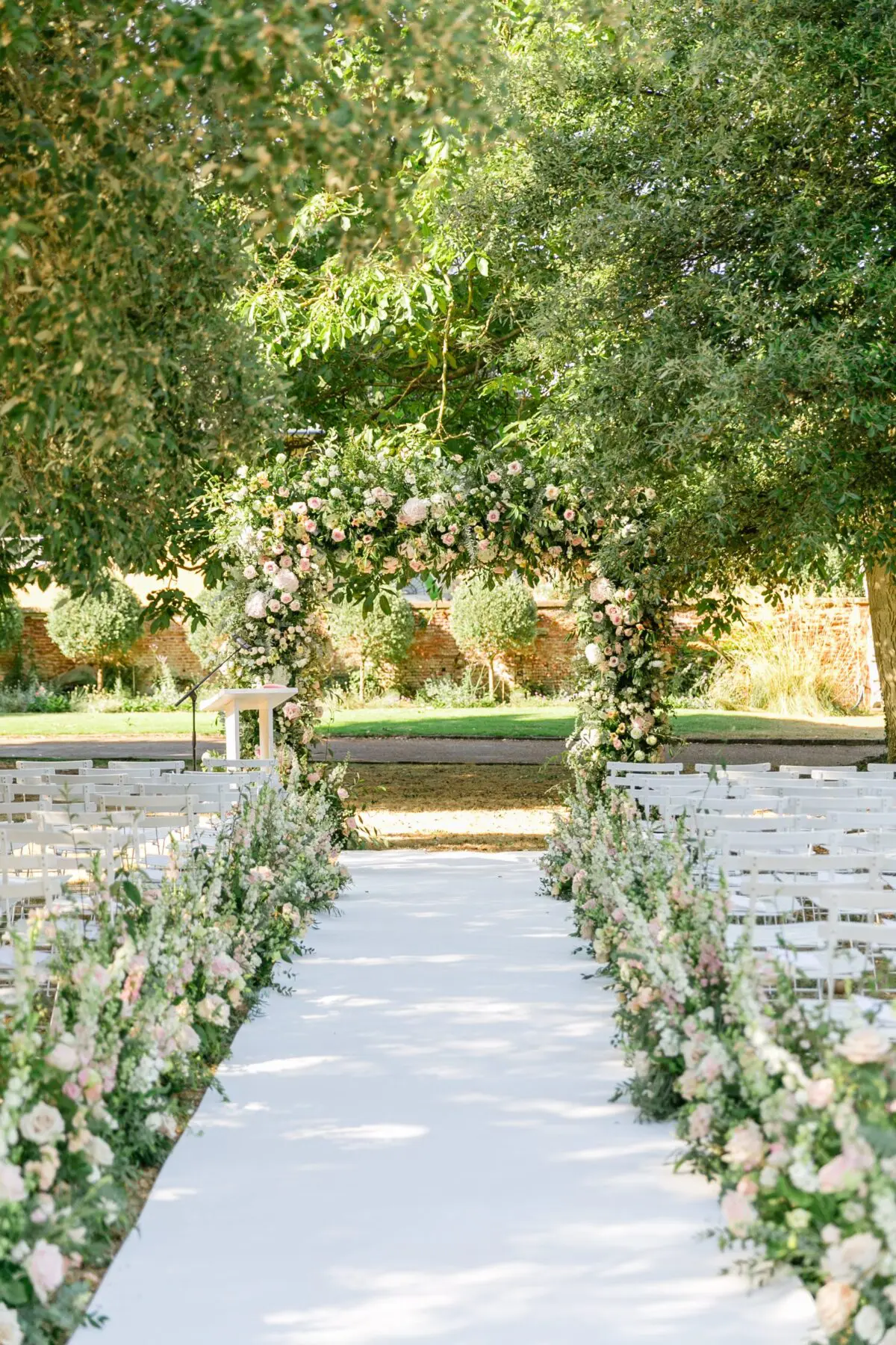 outdoor wedding ceremony meadow flowers and large floral arch - Syon Park Wedding