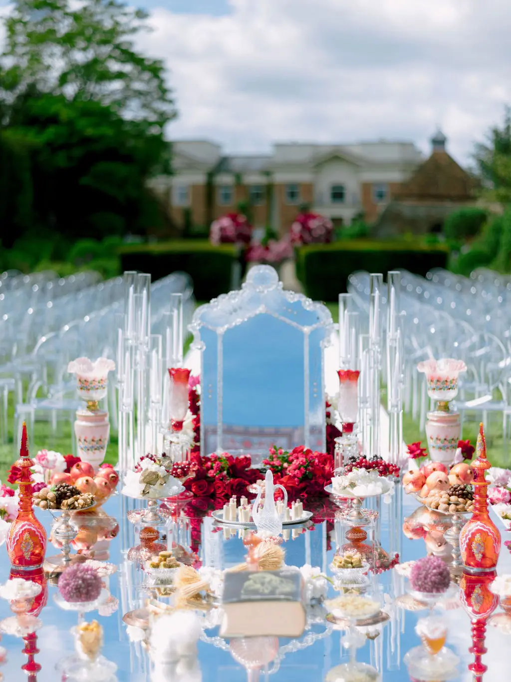 Mirrored Sofreh Aghd table with decorative items in pink and red at Four Seasons Hampshire in Walled Garden - Luxury Wedding & Events Planner