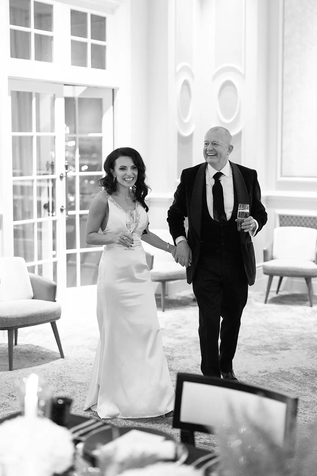 black and white image of bride and groom walking into ballroom at four seasons hampshire - monochrome wedding