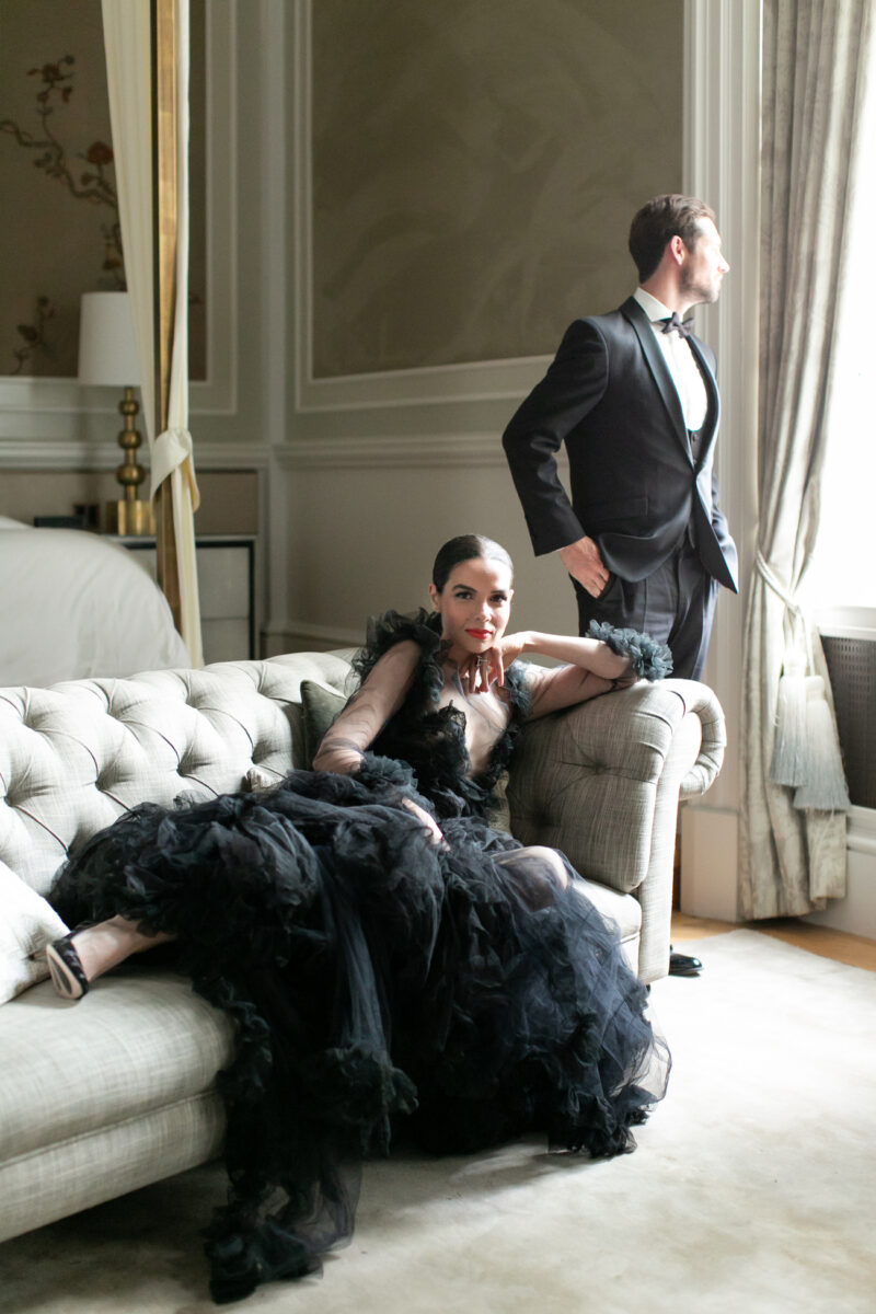 Lady in black dress lying on sofa and man looking out of the window | Luxury Event Planner
