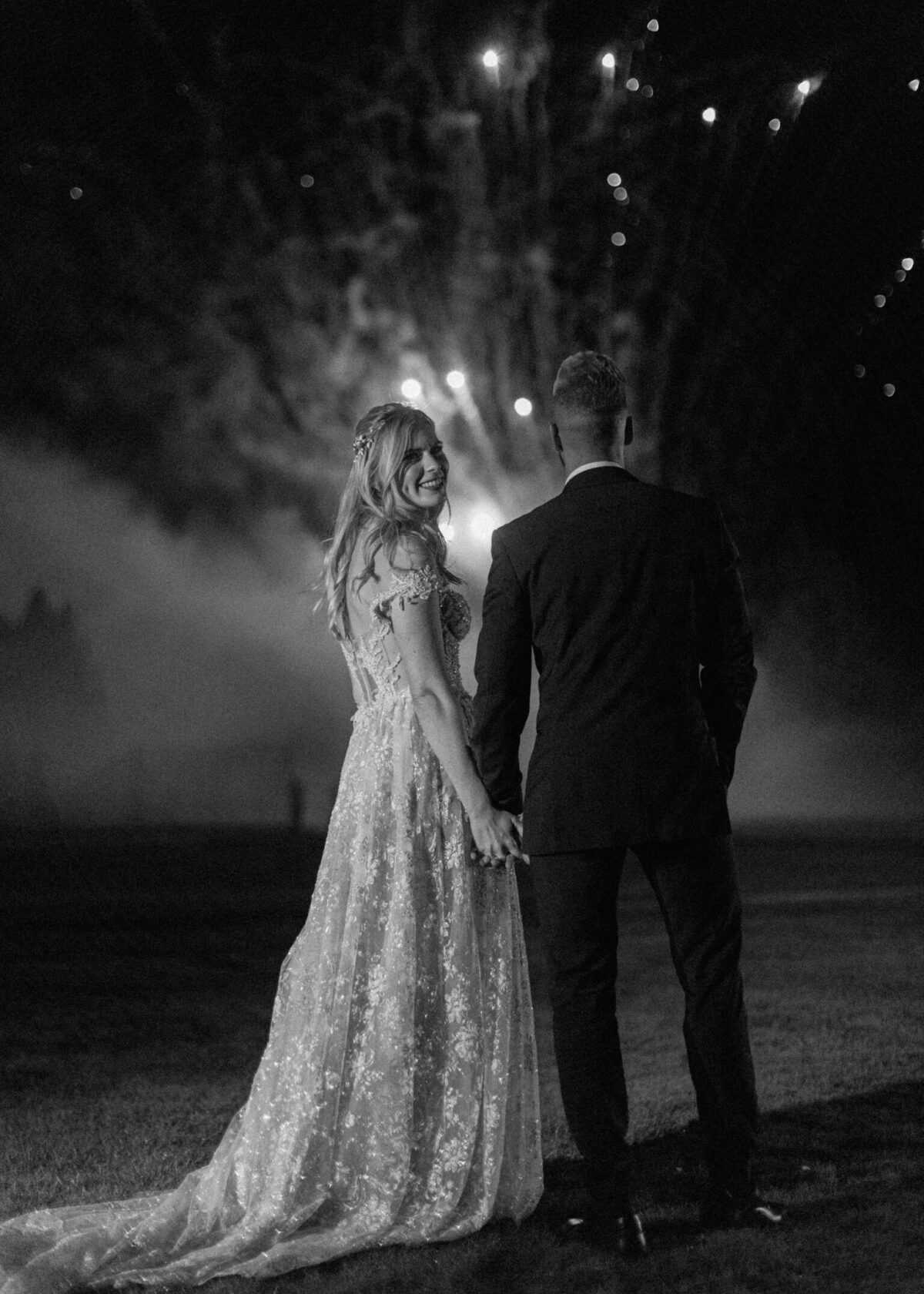 Black and white image of bride and groom watching fireworks