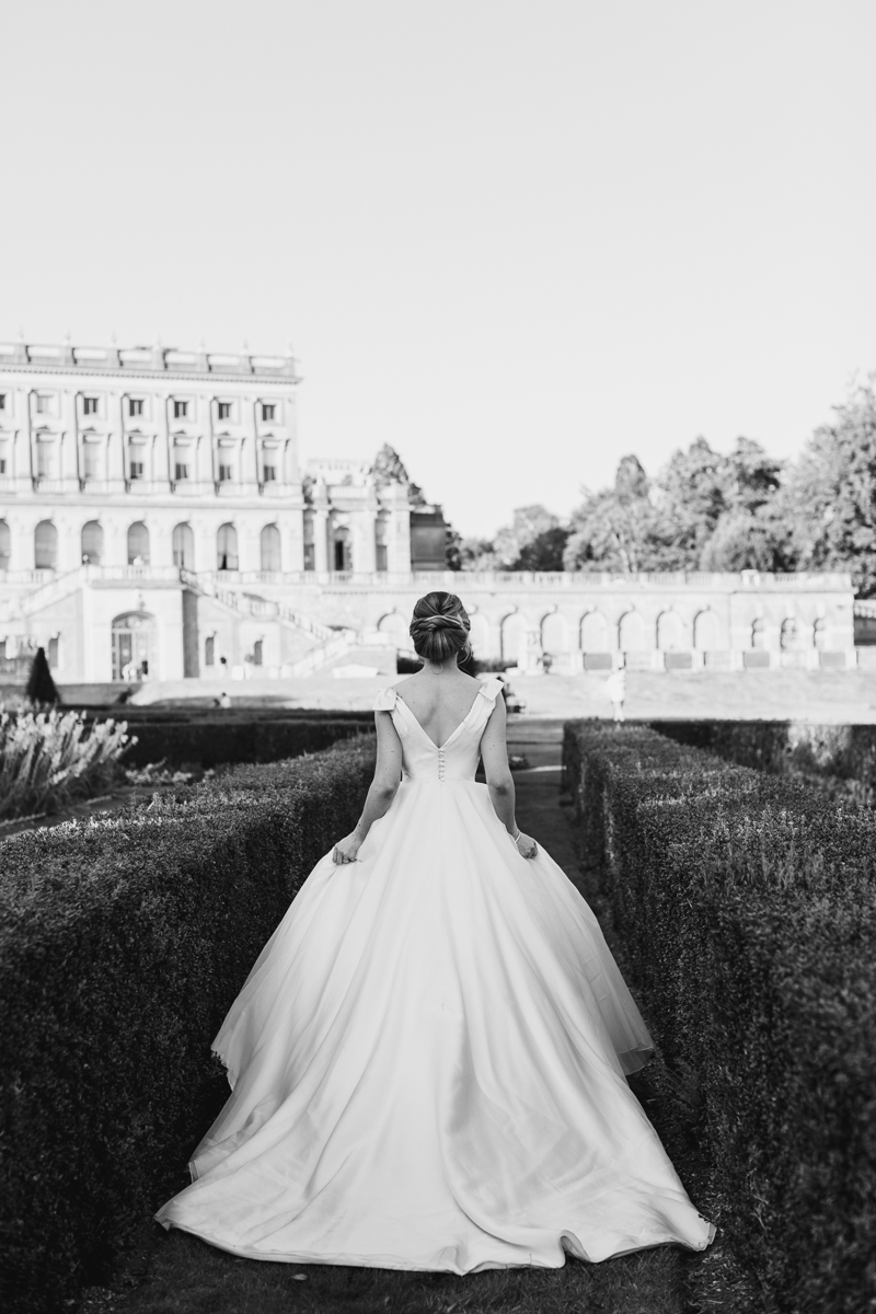 black and white image of bride running through garden