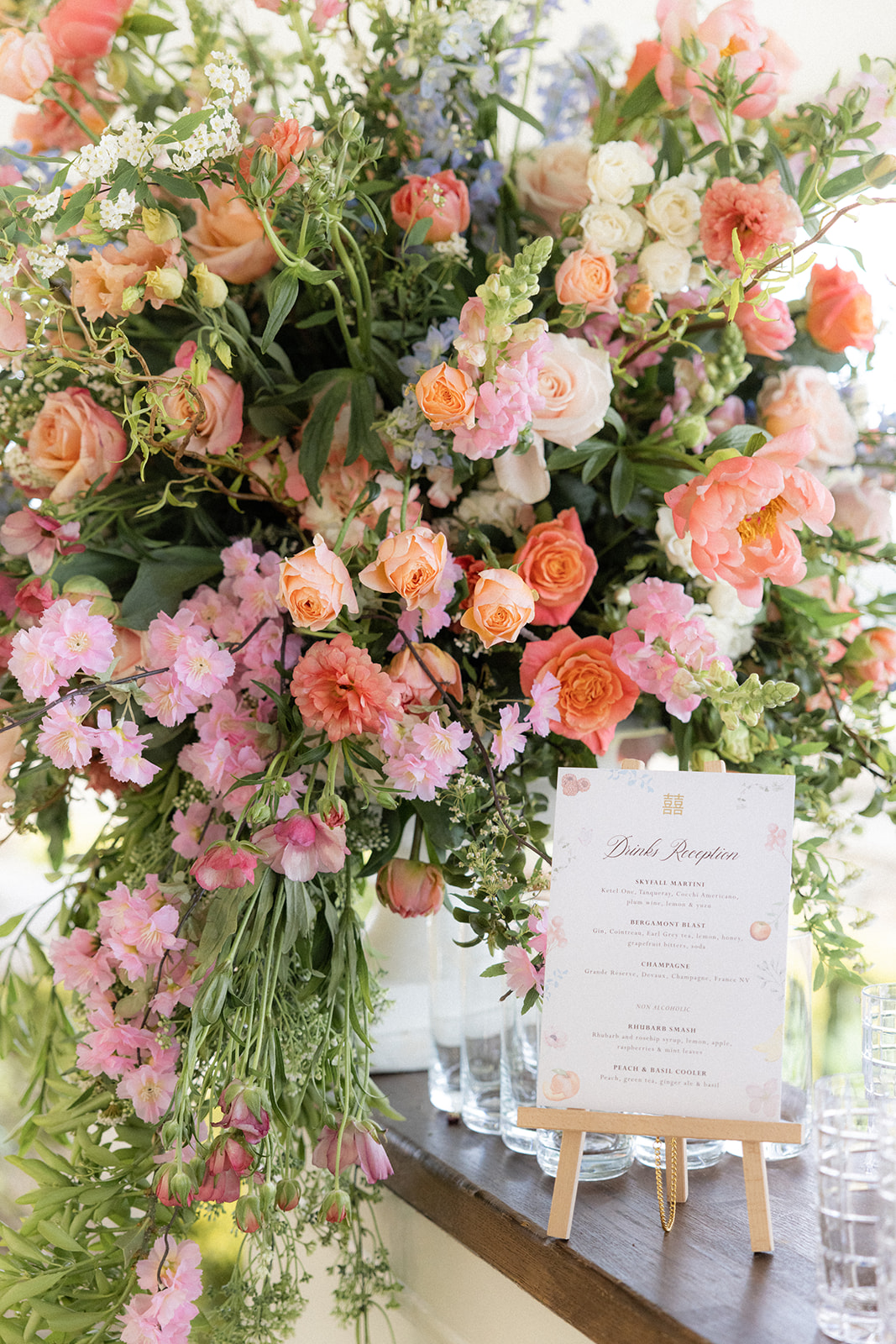 cocktail menu in front of floral display - wedding designer