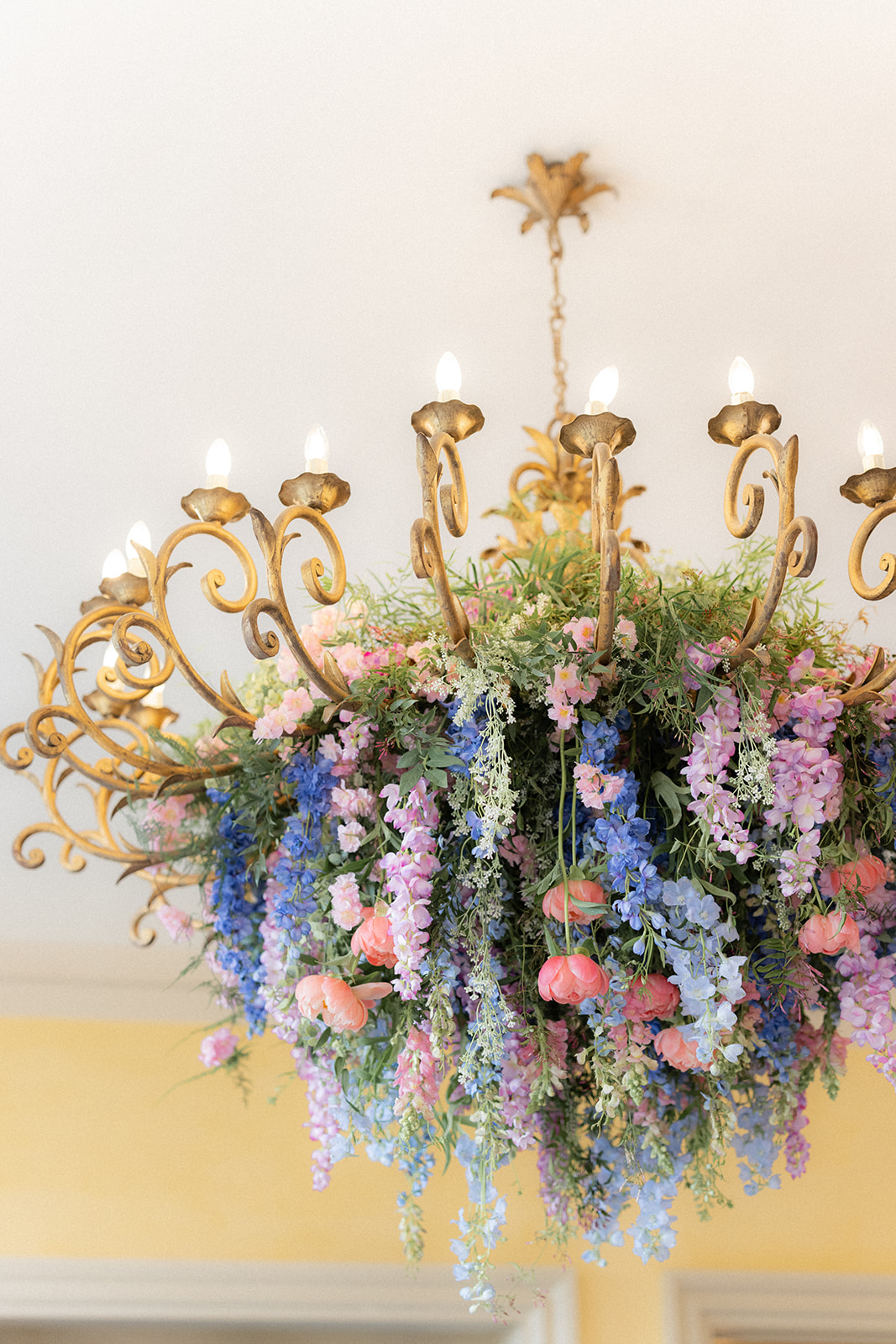 hanging flowers from chandelier in spring colours - wedding designer