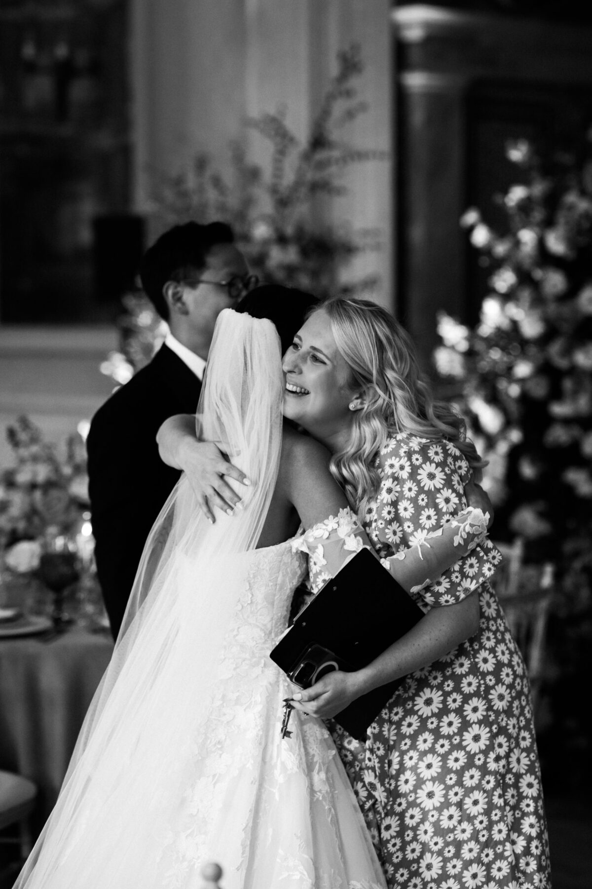 black and white image of Bride and groom hugging wedding planner - wedding designer