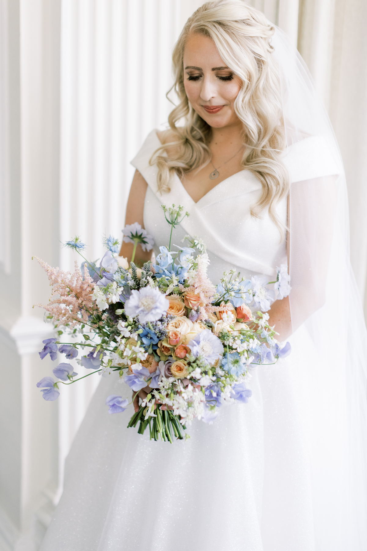 Hedsor House wedding Planner - bride looking down at bridal bouquet