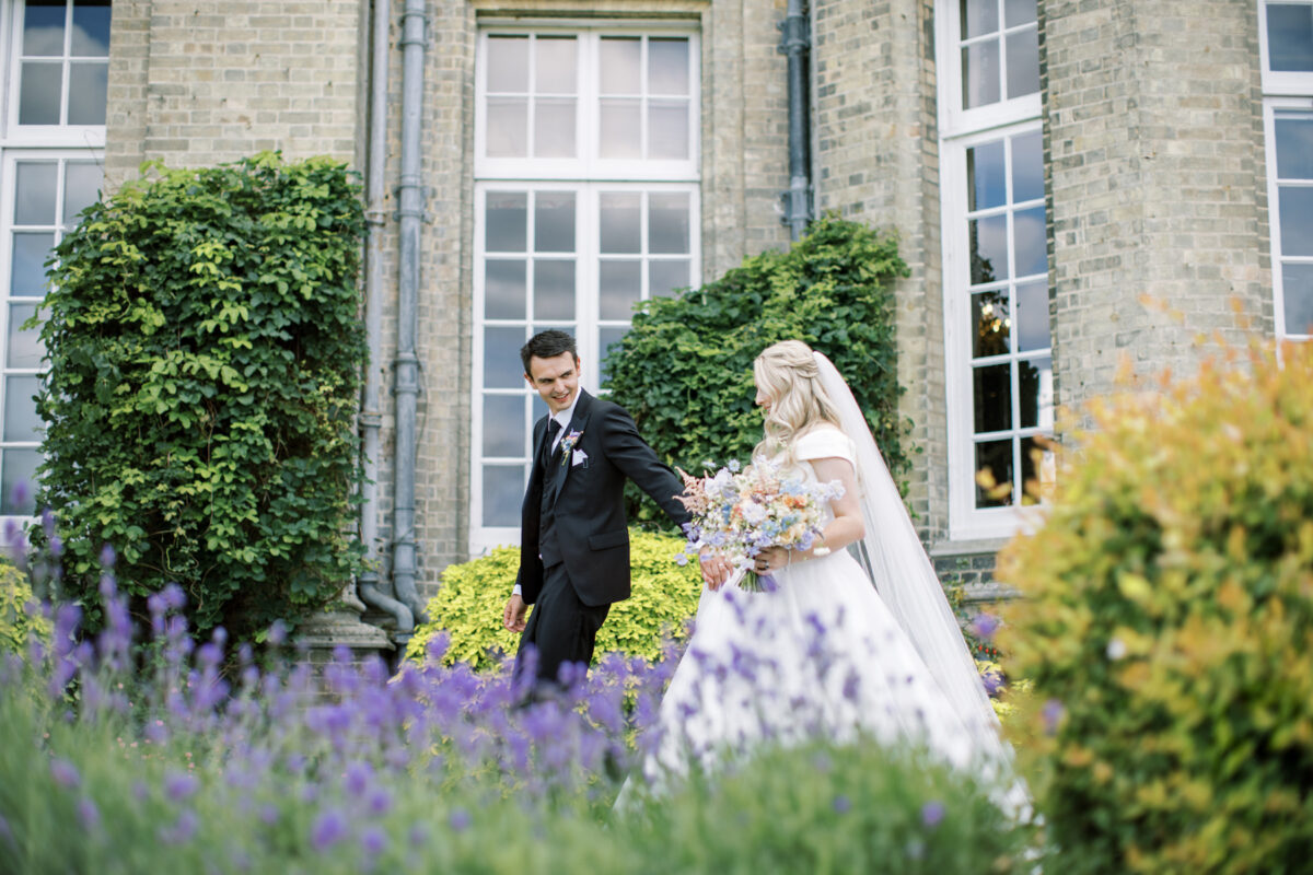 bride and groom walking through sunken garden at hedsor house