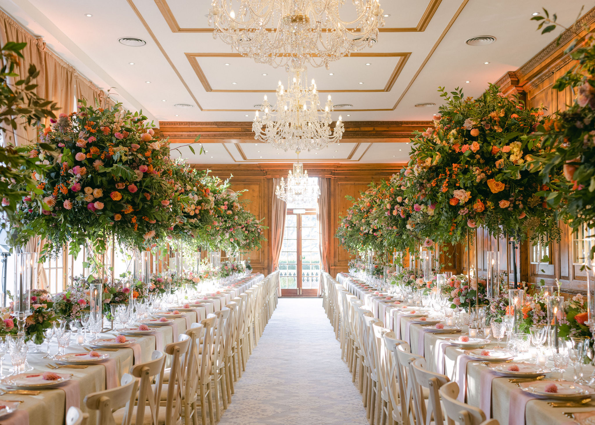 Two long tables dressed in autumnal theme with huge floral displays at Hedsor House