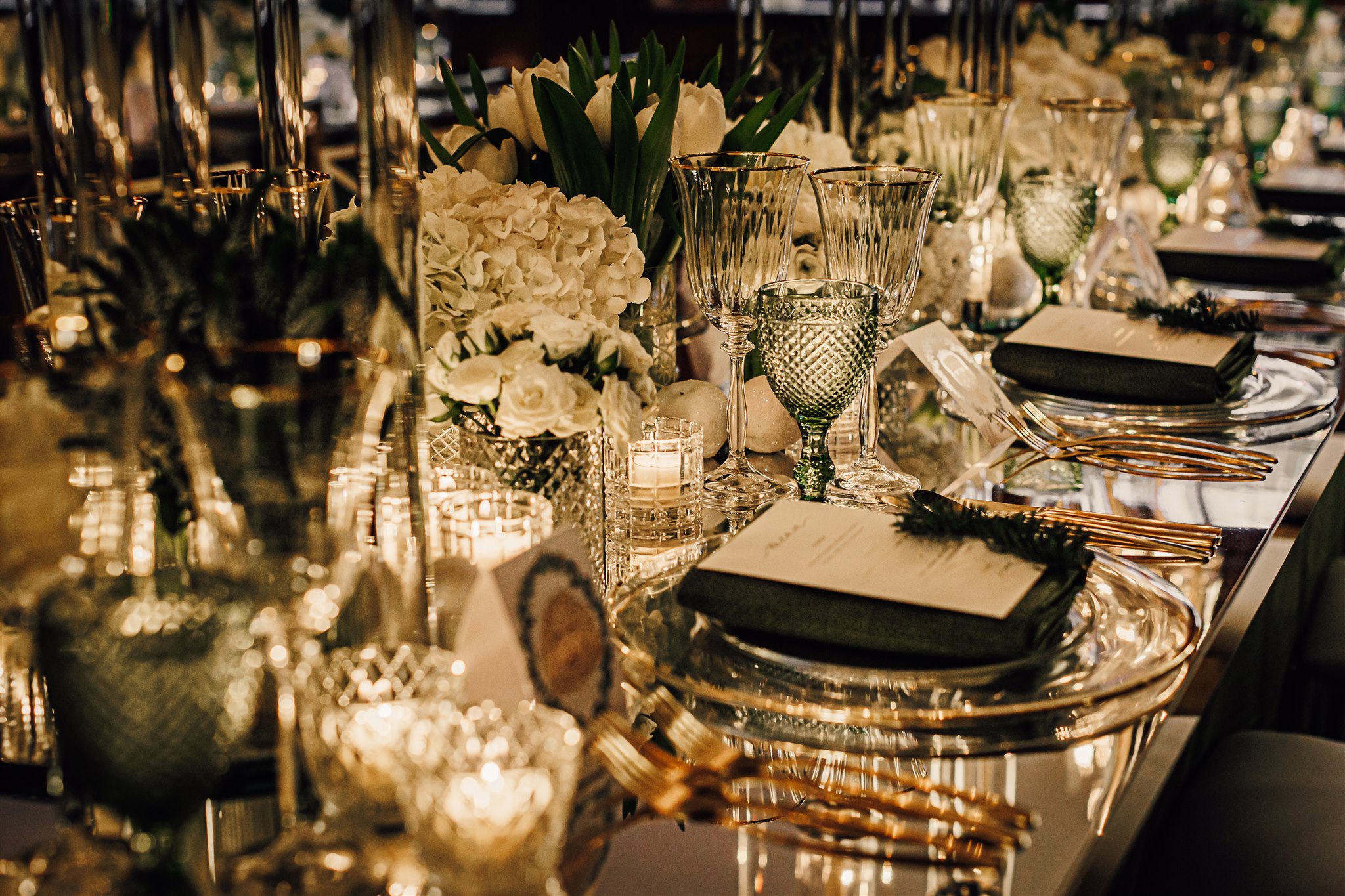 Close of table set up included gold mirrored top and green and glass tableware