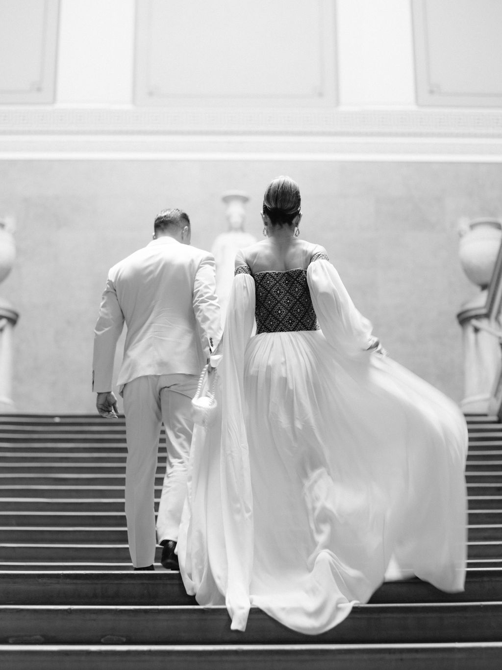 Bride & Groom at their pre wedding party walking up the stairs at The Wallace Collection - Luxury Wedding and Events Planner
