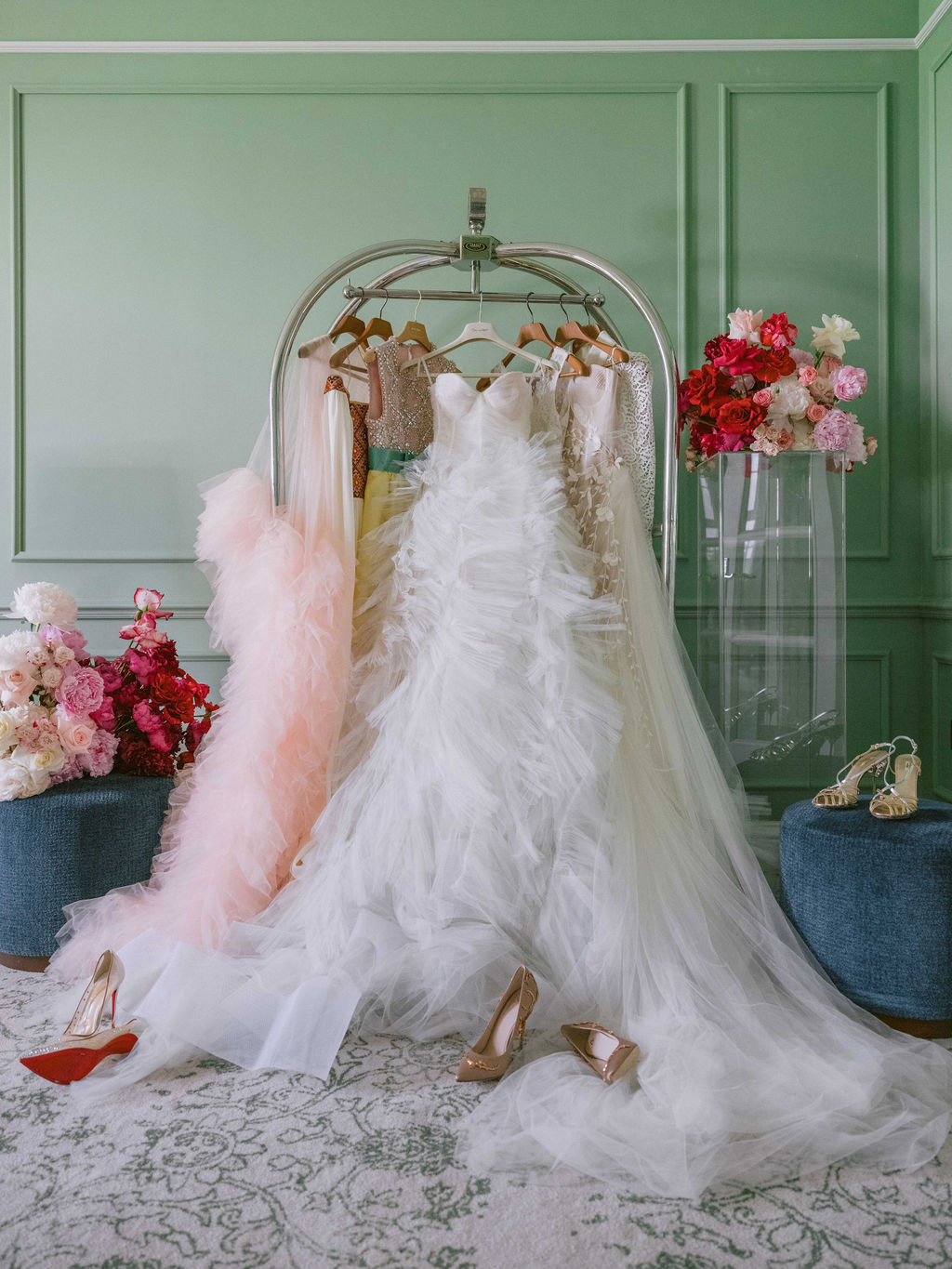 Brides dresses hanging in bridal suite surrounded by flowers