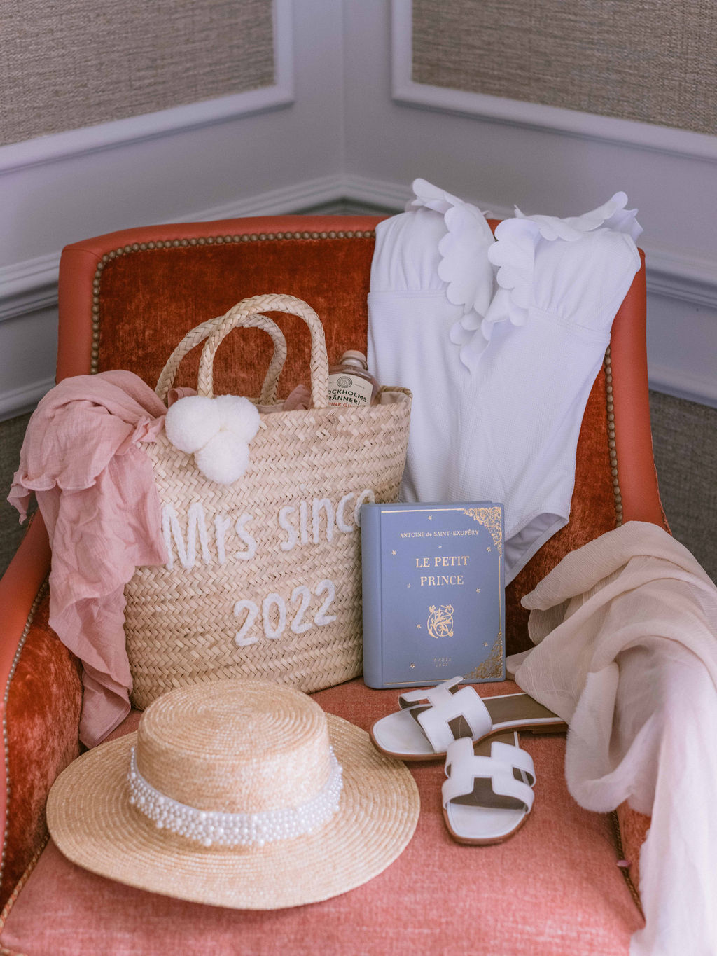 Honeymoon bag, hat, book and costume posed on chair at Four Seasons Hampshire